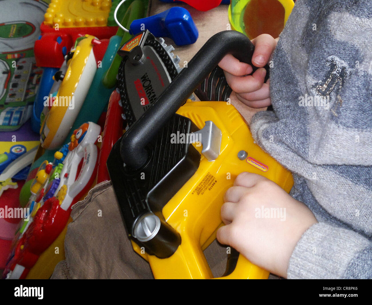 chainsaw toy child playing play room Stock Photo