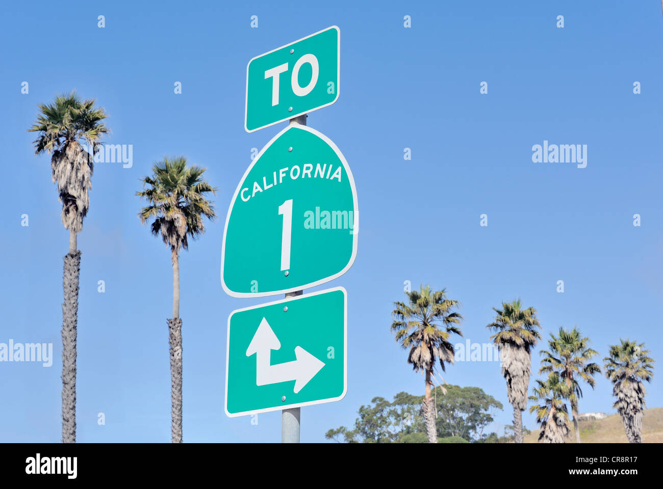 Road sign on highway one in California, USA with palm trees and sky Stock Photo