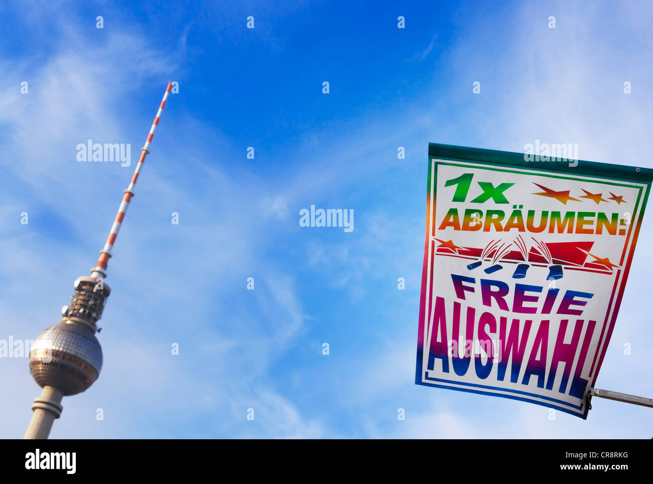 '1x abraeumen, freie Auswahl', German for 'clear all, free selection' on a fairground, banner in front of TV tower at Stock Photo