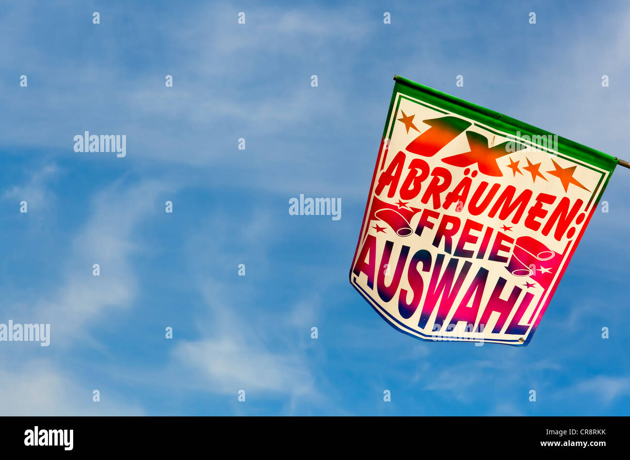 '1x abraeumen, freie Auswahl', German for 'clear all, free selection' on a fairground, banner against a blue sky, Stock Photo