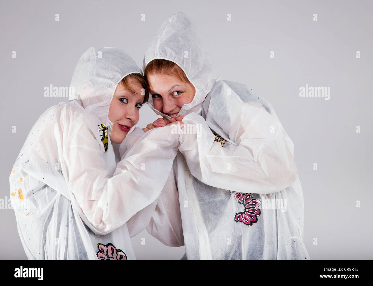 Cheeky girls wearing white protective suits Stock Photo