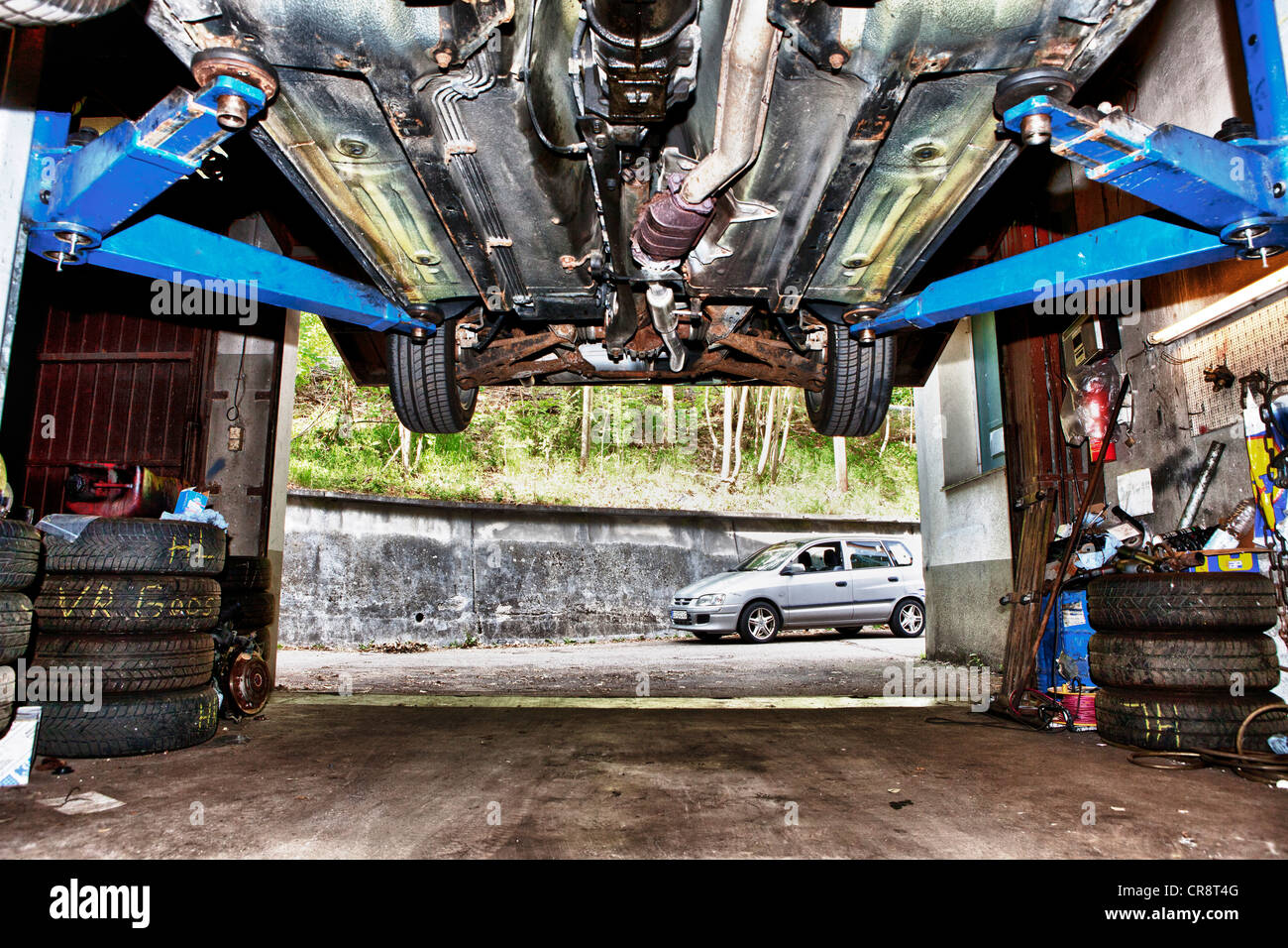 Car on a lift in a garage, worm's eye view Stock Photo - Alamy