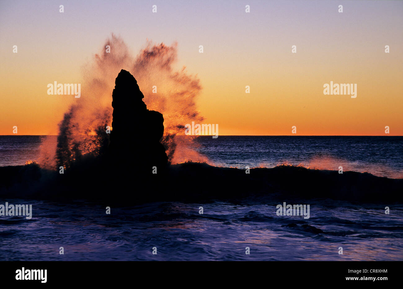 Waves breaking on one of the rocks of Mussel Point at Haast Beach, West Coast, South Island, New Zealand Stock Photo