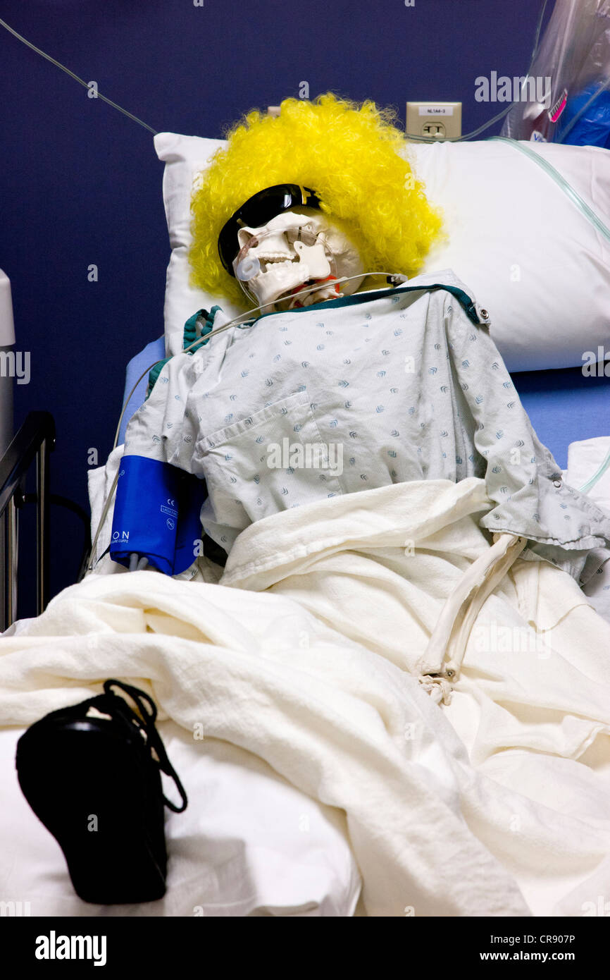 Hospital patient in bed, a skeleton with yellow wig Stock Photo