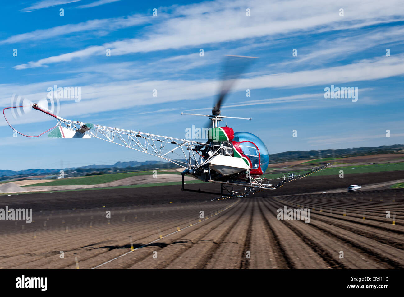 Bell 47 helicopter spraying crops in the Salinas Valley, California