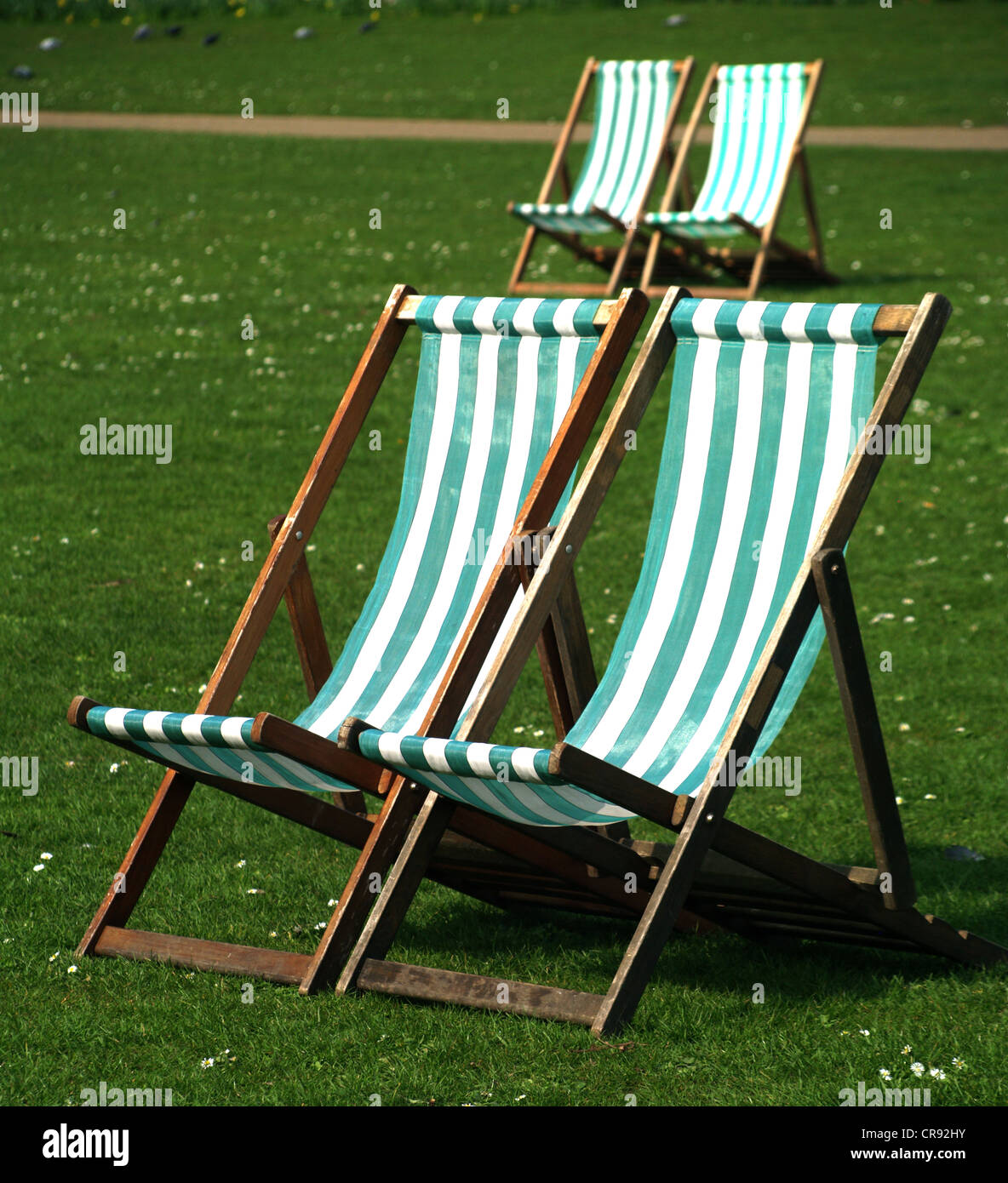 Four deck chairs on grass with daisies in St. James Park, London Stock Photo Alamy