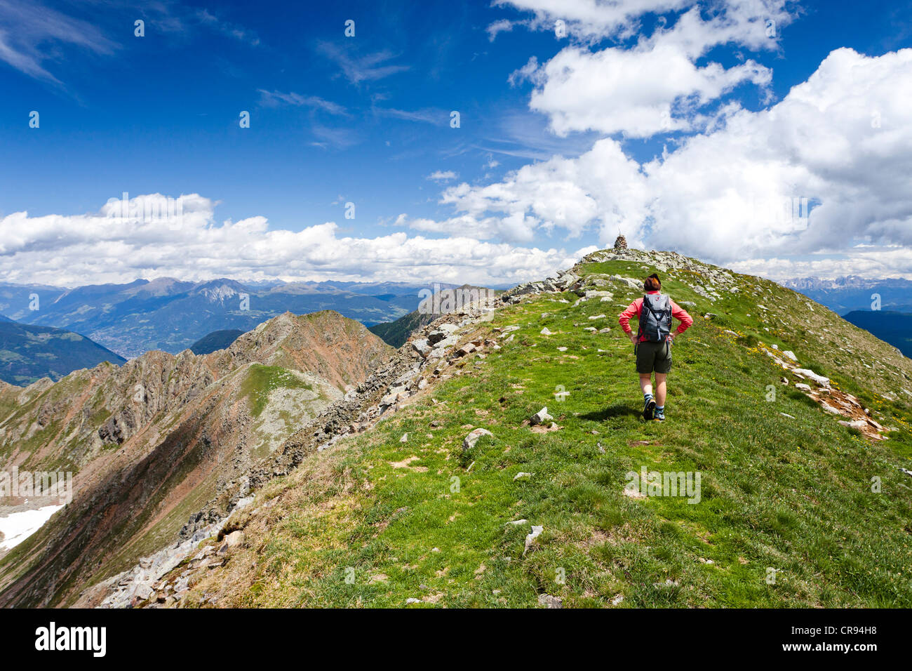 Hiker on the ridge from Mt Schoengrubspitze to Mt Kornigl, reaching the summit, Ulten Valley, Val d'Ultimo, Etschtal valley or Stock Photo