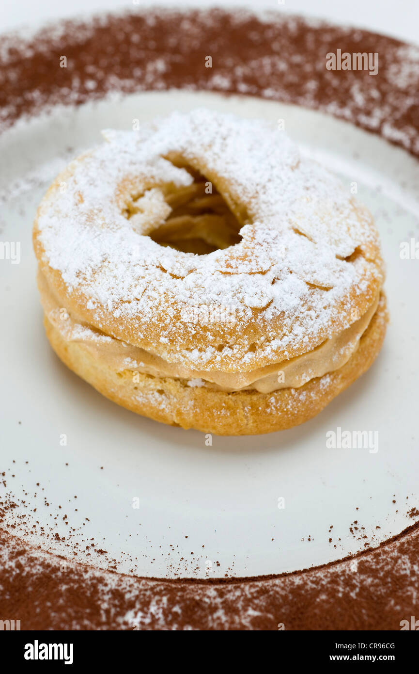 French pastries "Paris-Brest" named after the cycling race, choux pastry with different fillings, originally with butter cream Stock Photo