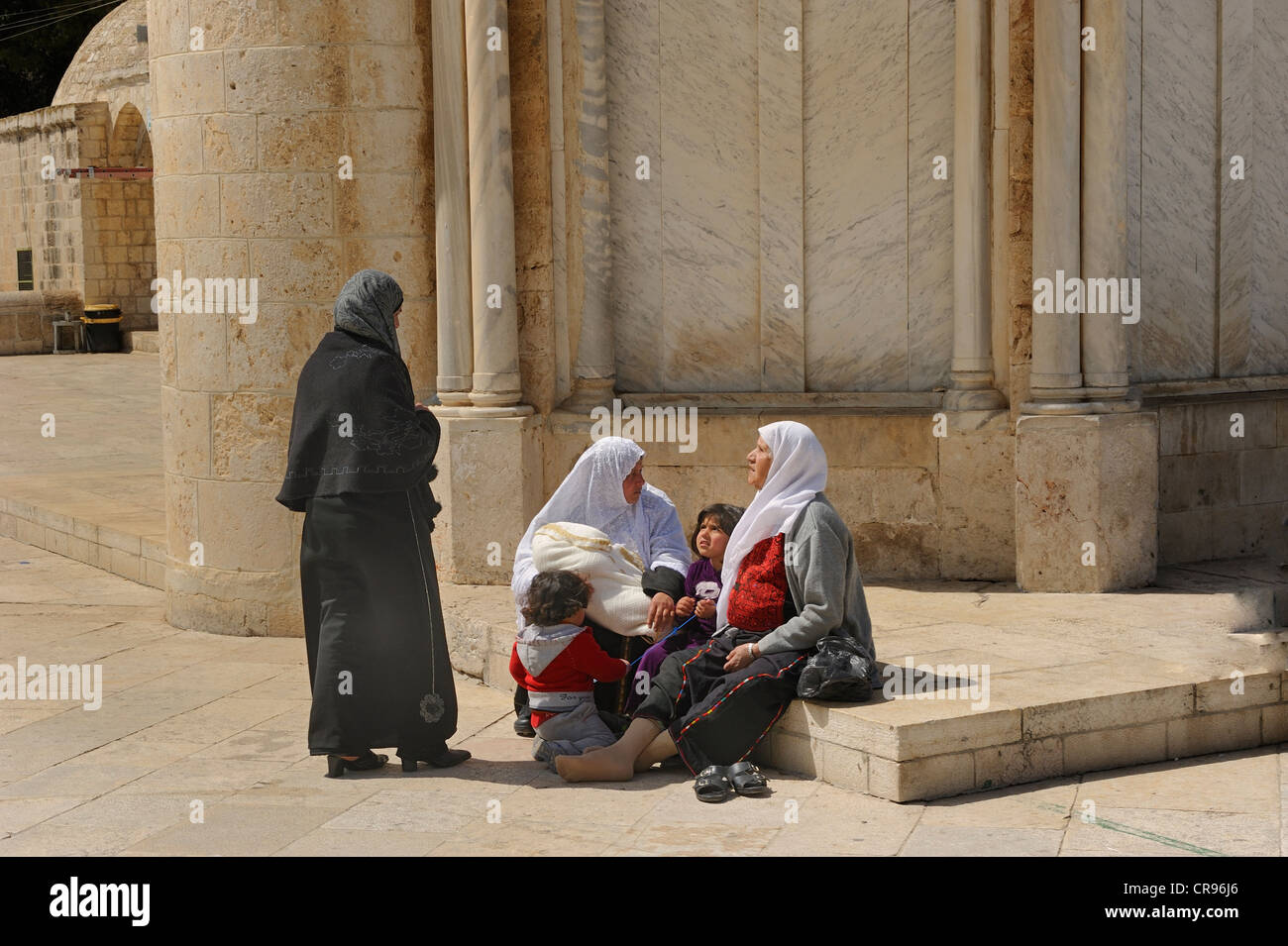 Israeli Palestinian women wearing headscarves resting with their children on the base of the Ascension Church, Temple Mount Stock Photo