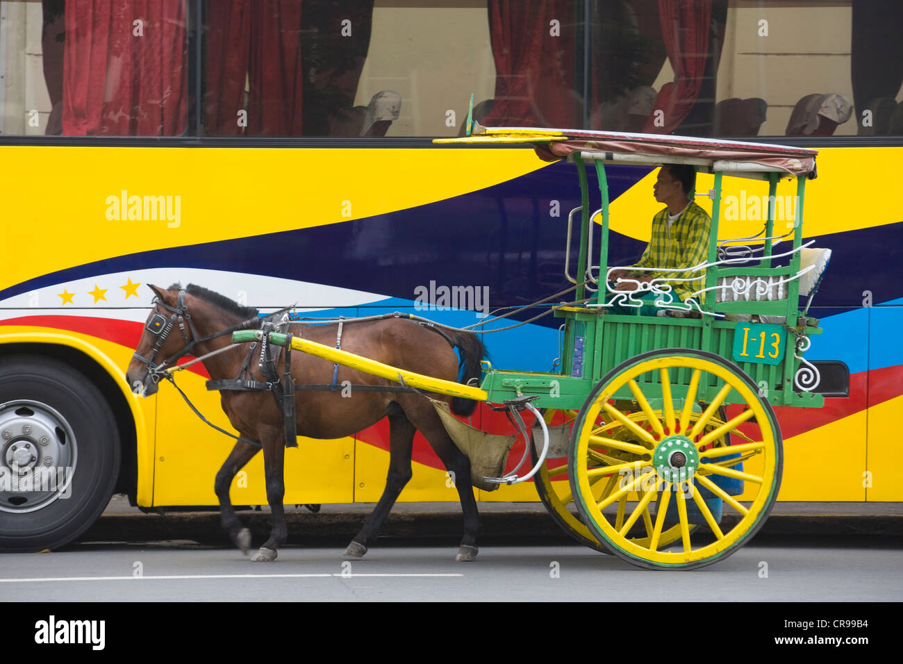 Horse cart walk by colorfully painted bus, Manila, Philippines Stock Photo