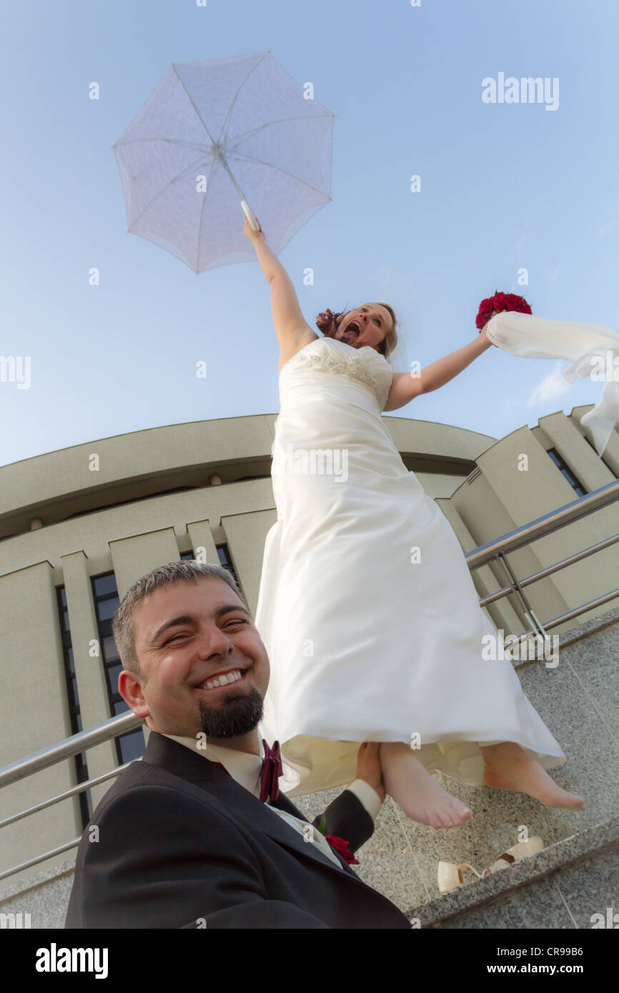 The groom can not escape the bride with umbrella Stock Photo - Alamy