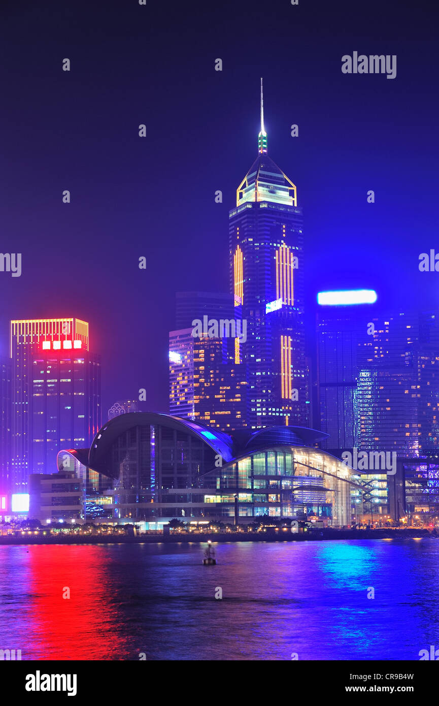 Hong Kong city skyline at night over Victoria Harbor with clear sky and urban skyscrapers. Stock Photo