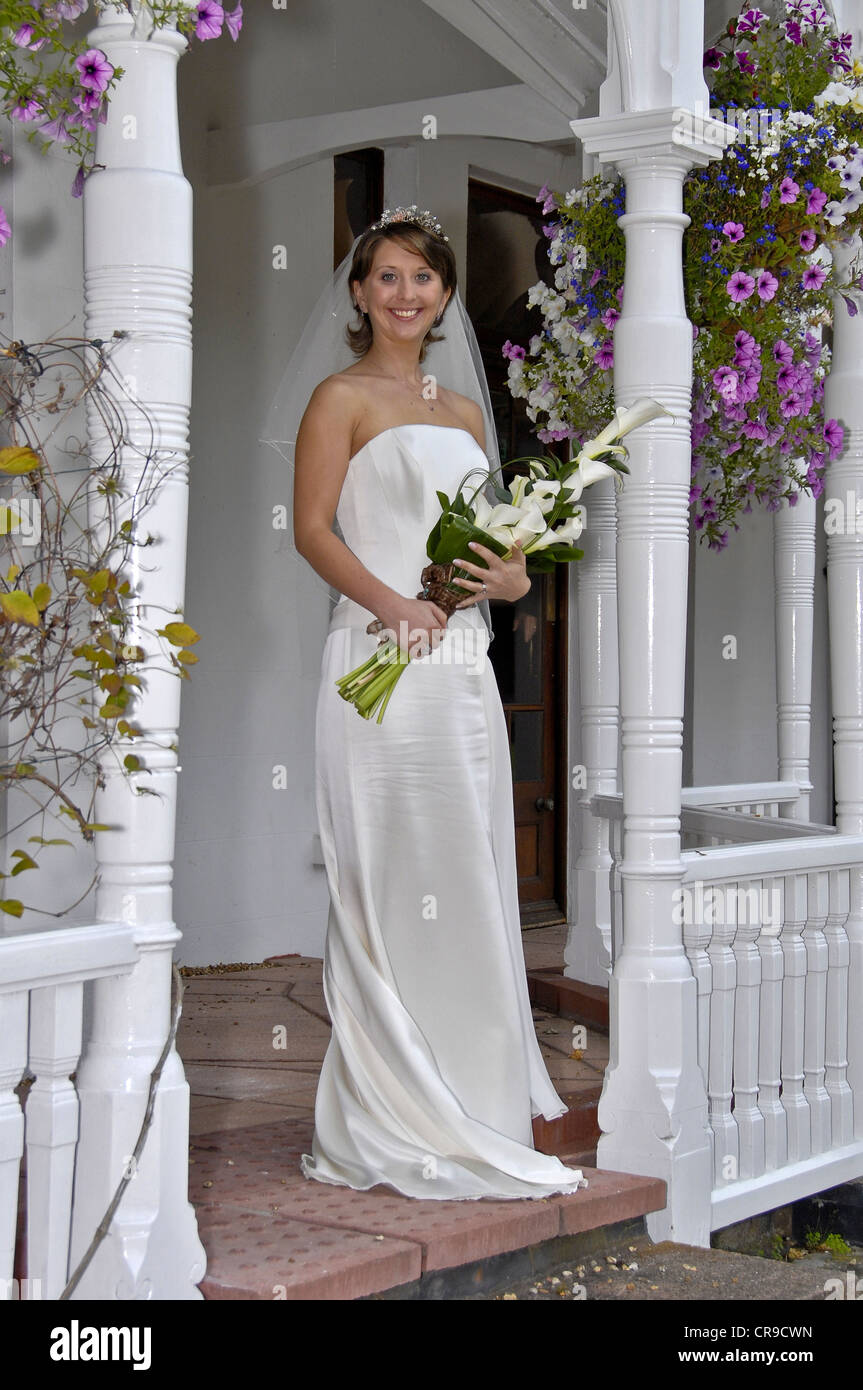 Bride Posing With White Wedding Dress And White Lily Bouquet On A