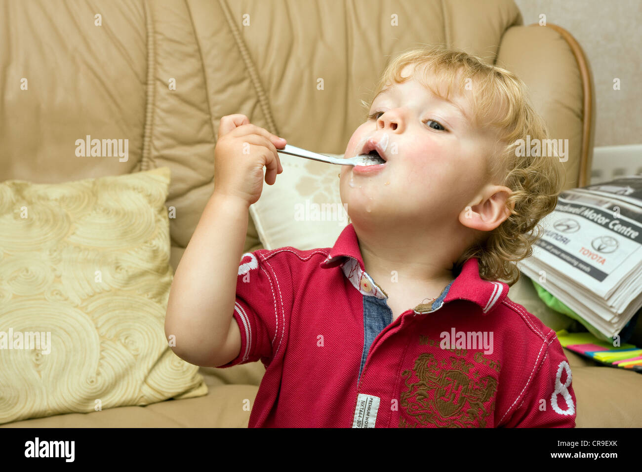 toddler eating spoon mouth looking up Stock Photo Alamy