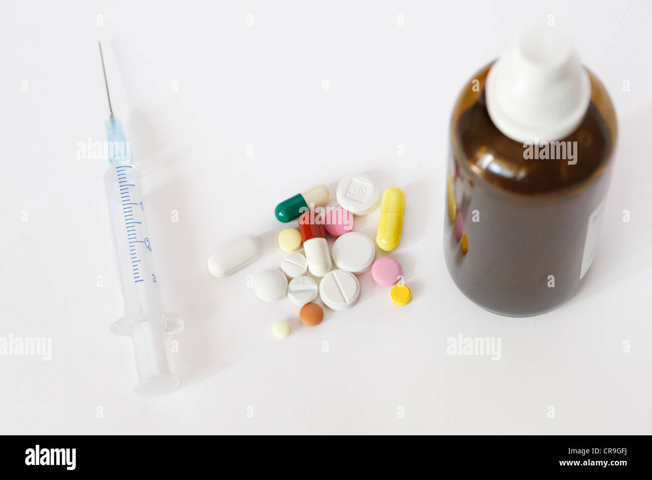 Syringe, pills and solution in the small brown vial on white background Stock Photo