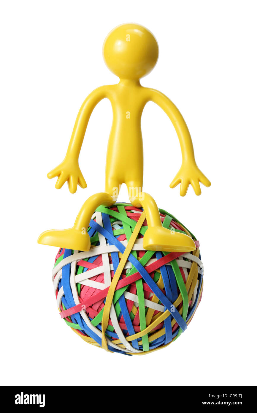 Miniature Rubber Figure Sitting on Rubberband Ball Stock Photo