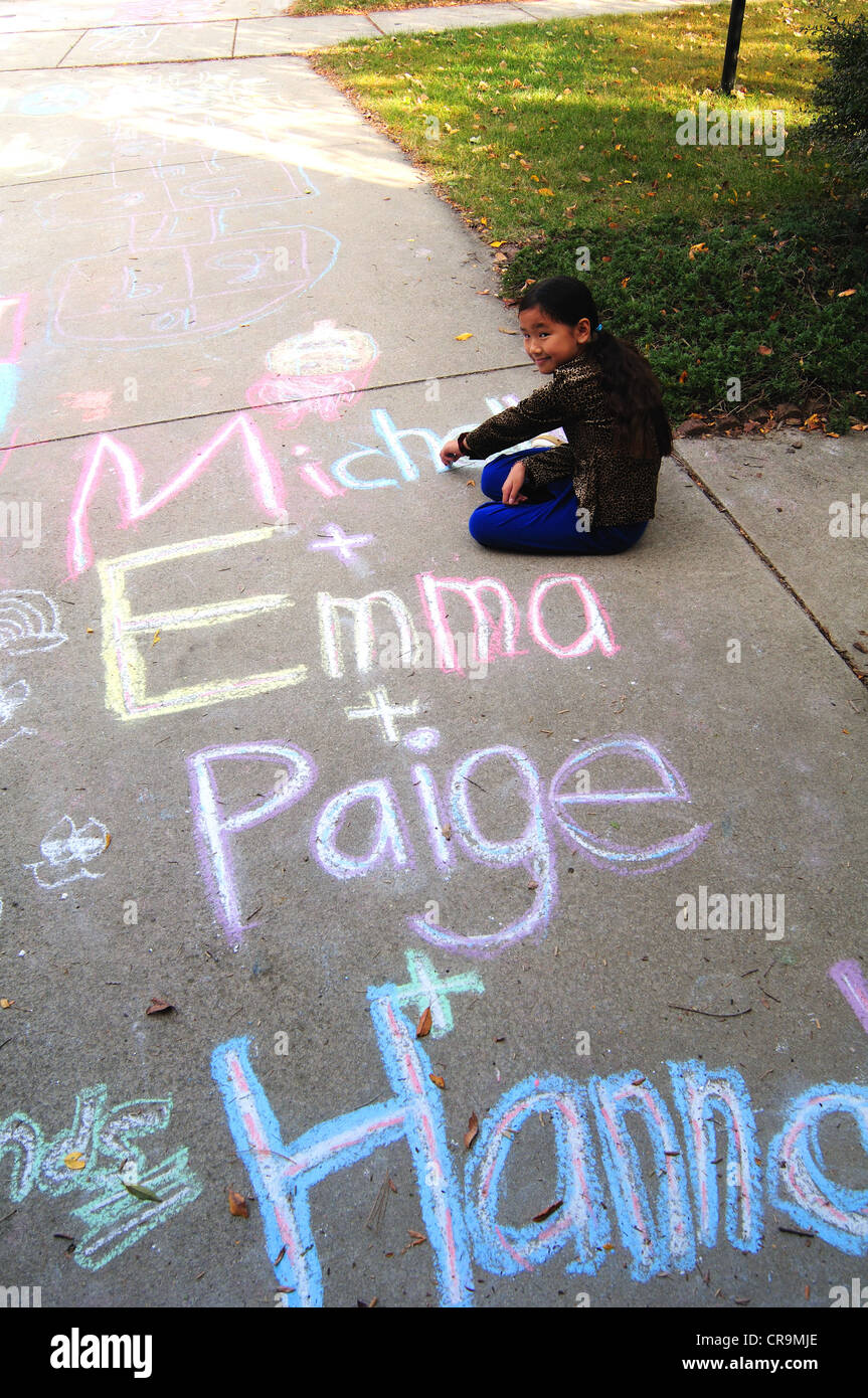 Young Asian girl using drawing with sidewalk chalk Stock Photo - Alamy