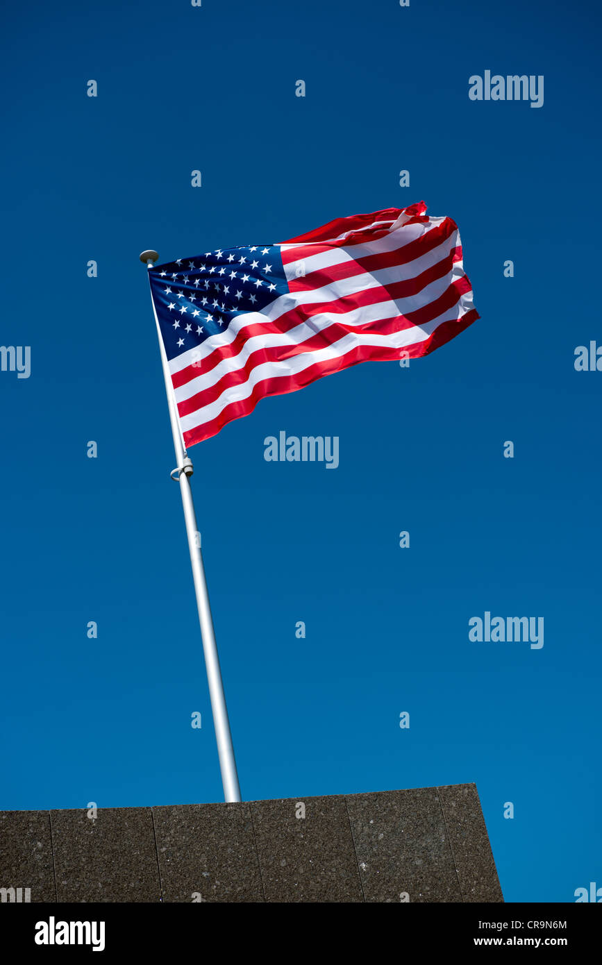 The American flag fluttering atop a flagpole Stock Photo