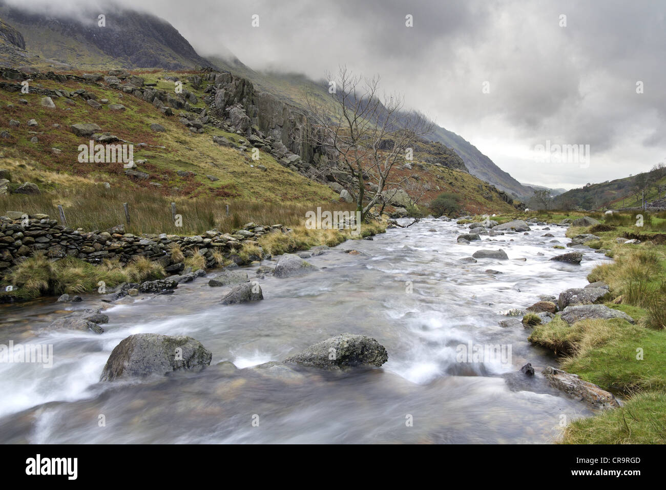 The water of the Afon Nant Peris flows through the Pass of Llanberis toward the town of Llanberis. Stock Photo