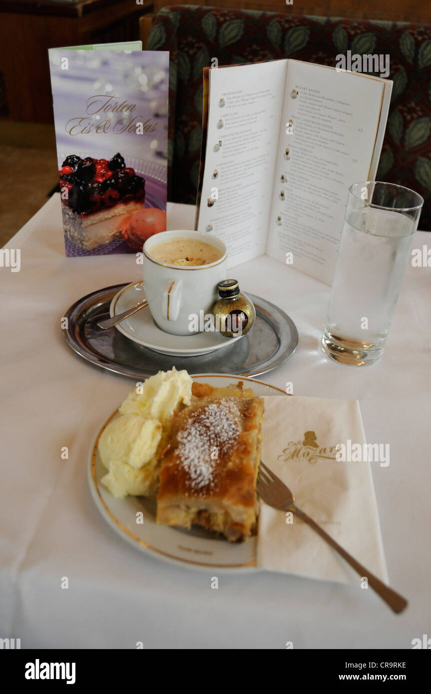One of the many Austrian café treats, a cup of double espresso with Mozart liqueur, whipped cream and almonds with an apple strudel, fresh cream and Stock Photo