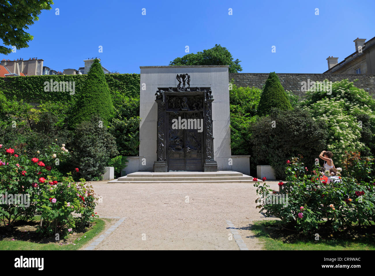 Gardens of the Rodin Museum in Paris. The sculpture The Gates of Hell is set amid rose bushes in the garden of the musuem. Stock Photo
