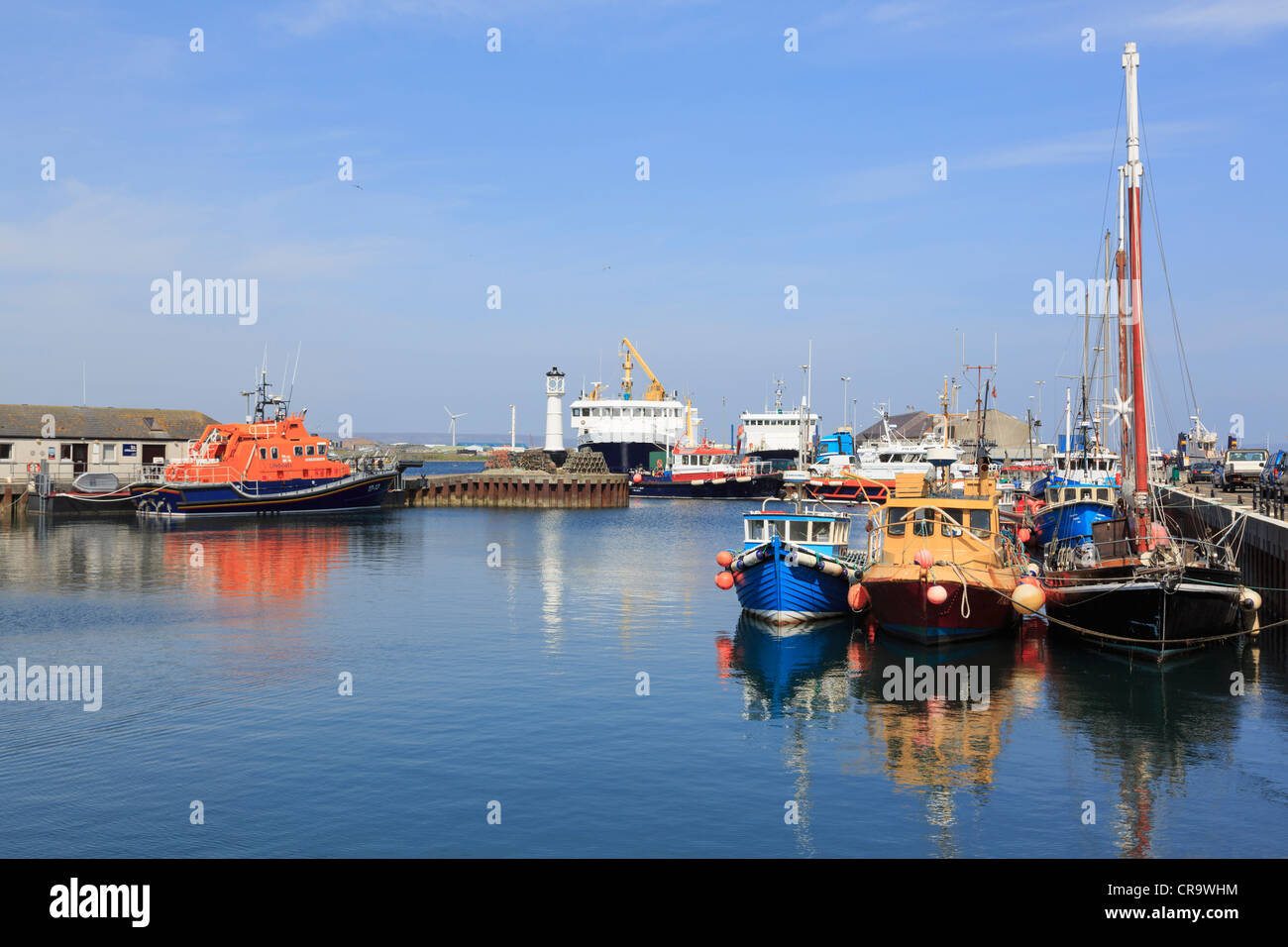 Fishing boats moored in inner harbour with the lifeboat and ferry ...