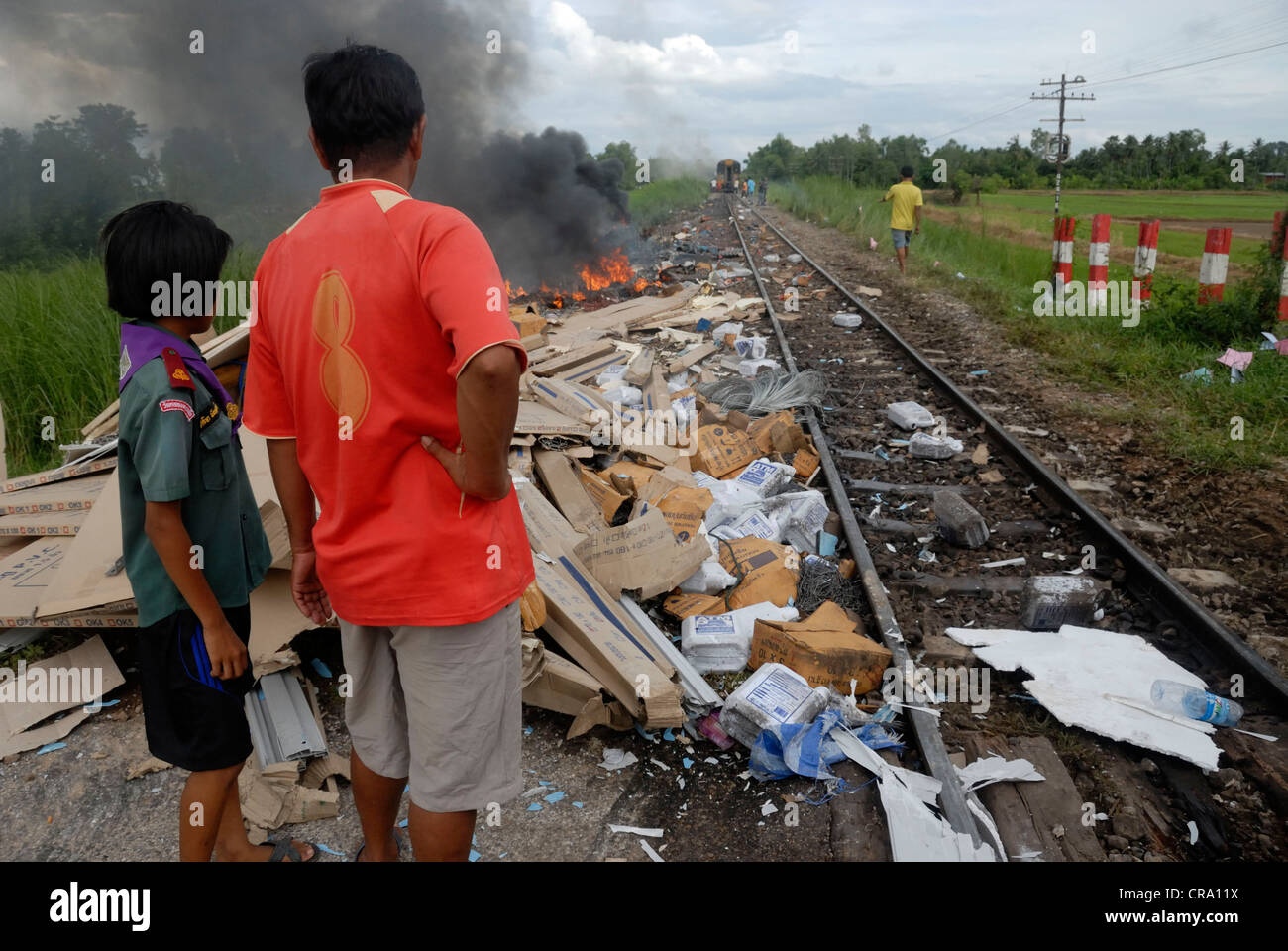 Two children looking at the rubble left from the crashed train up ahead on 14/06/2011 in Phitsanulok Thailand Stock Photo