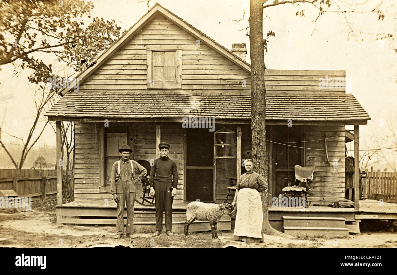 Poor Family in front of Shack with Sheep Stock Photo