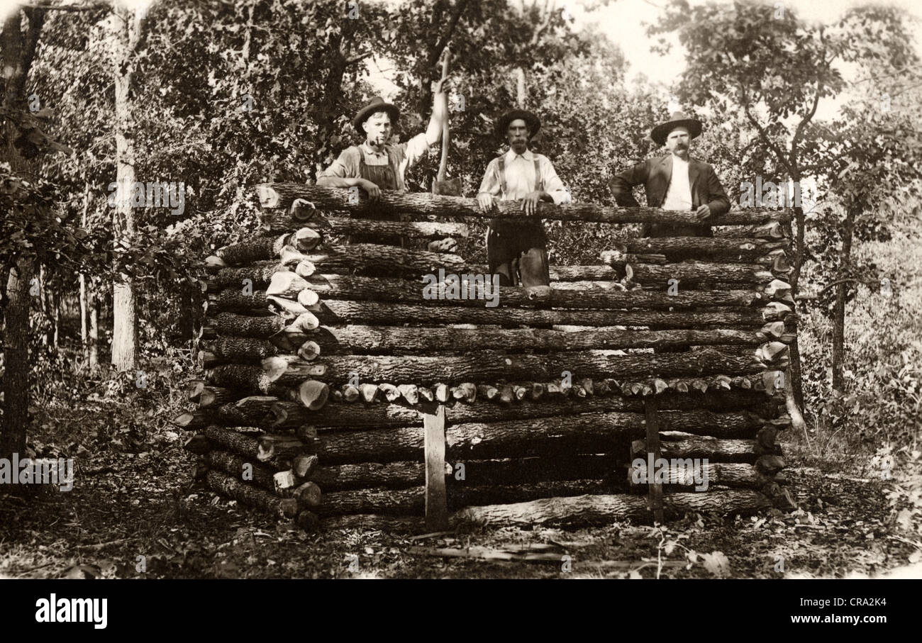 Three Men Building Tiny Log Cabin Fort Stock Photo