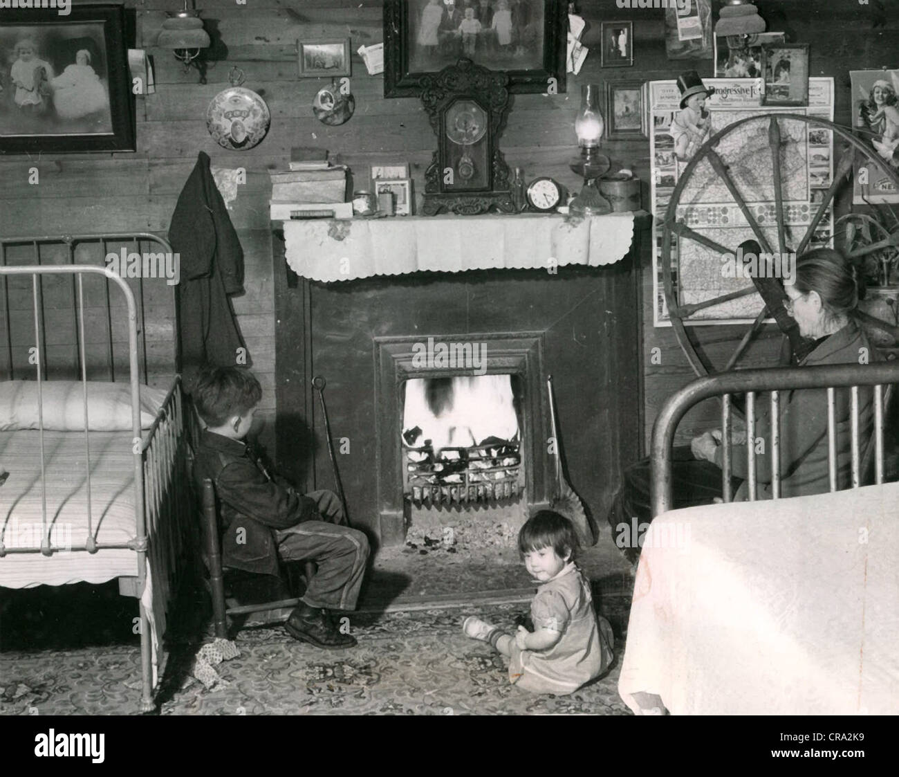 Grandmother & Grandchildren Sit before Blazing Fire Stock Photo