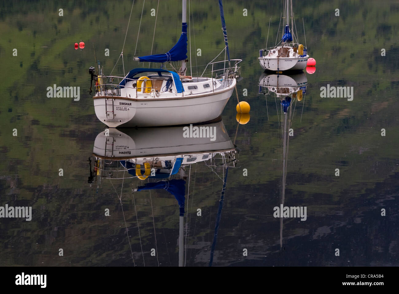 Boats reflected on the calm waters of Loch Leven in Scotland. Stock Photo