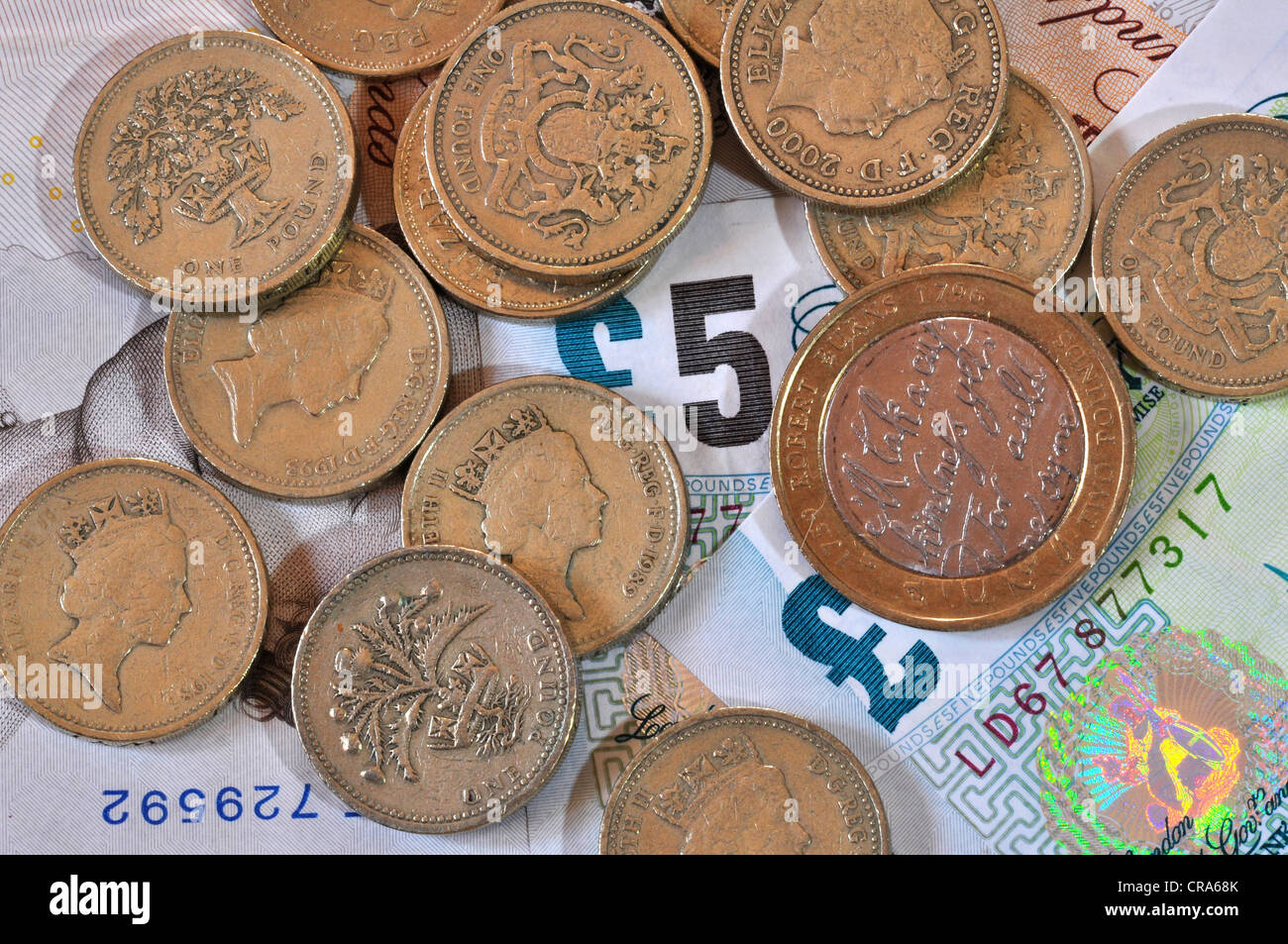 Five pound notes and pound coins UK Stock Photo