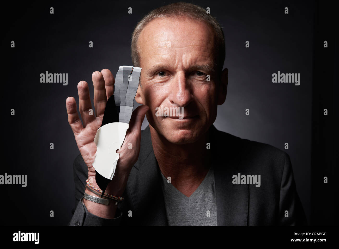 Analogue music lover holding up a piece of a broken record Stock Photo