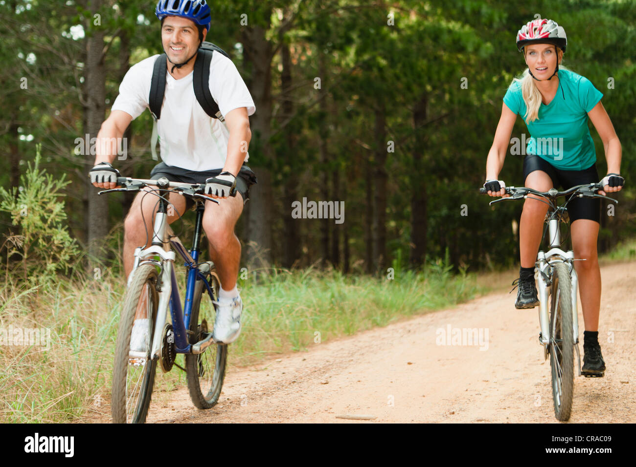 Couple mountain biking on dirt road Stock Photo Alamy