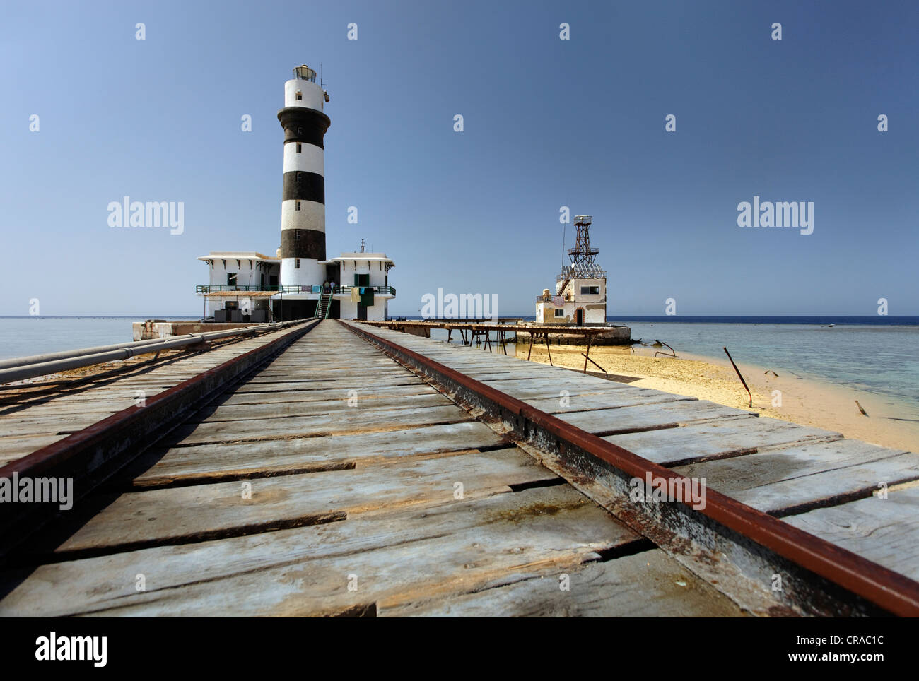 Rails, lighthouse with adjoining building, jetty and reef top, Daedalus Reef, Egypt, Red Sea, Africa Stock Photo