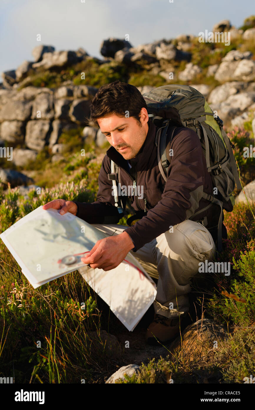 Hiker reading map in rocky field Stock Photo - Alamy