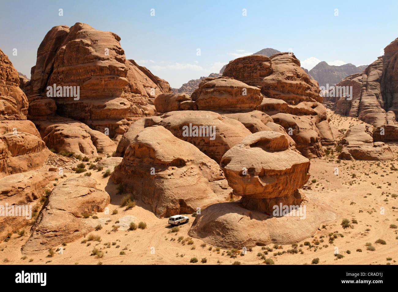 Off-road vehicle driving between rocks in the desert, Wadi Rum, Hashemite Kingdom of Jordan, Middle East, Asia Stock Photo