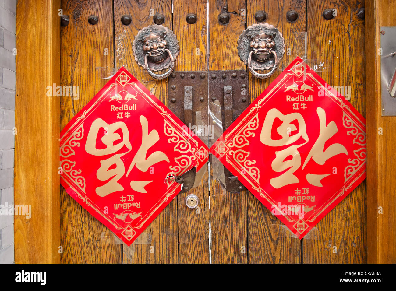 Old wooden doors at entrance to traditional courtyard house in a Beijing hutong or lane in China Stock Photo