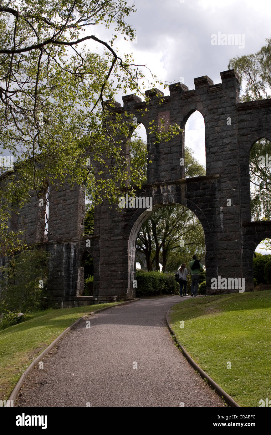 A young couple walking through the entrance to McCaig's Tower on Battery Hill in Oban, Scotland. Stock Photo