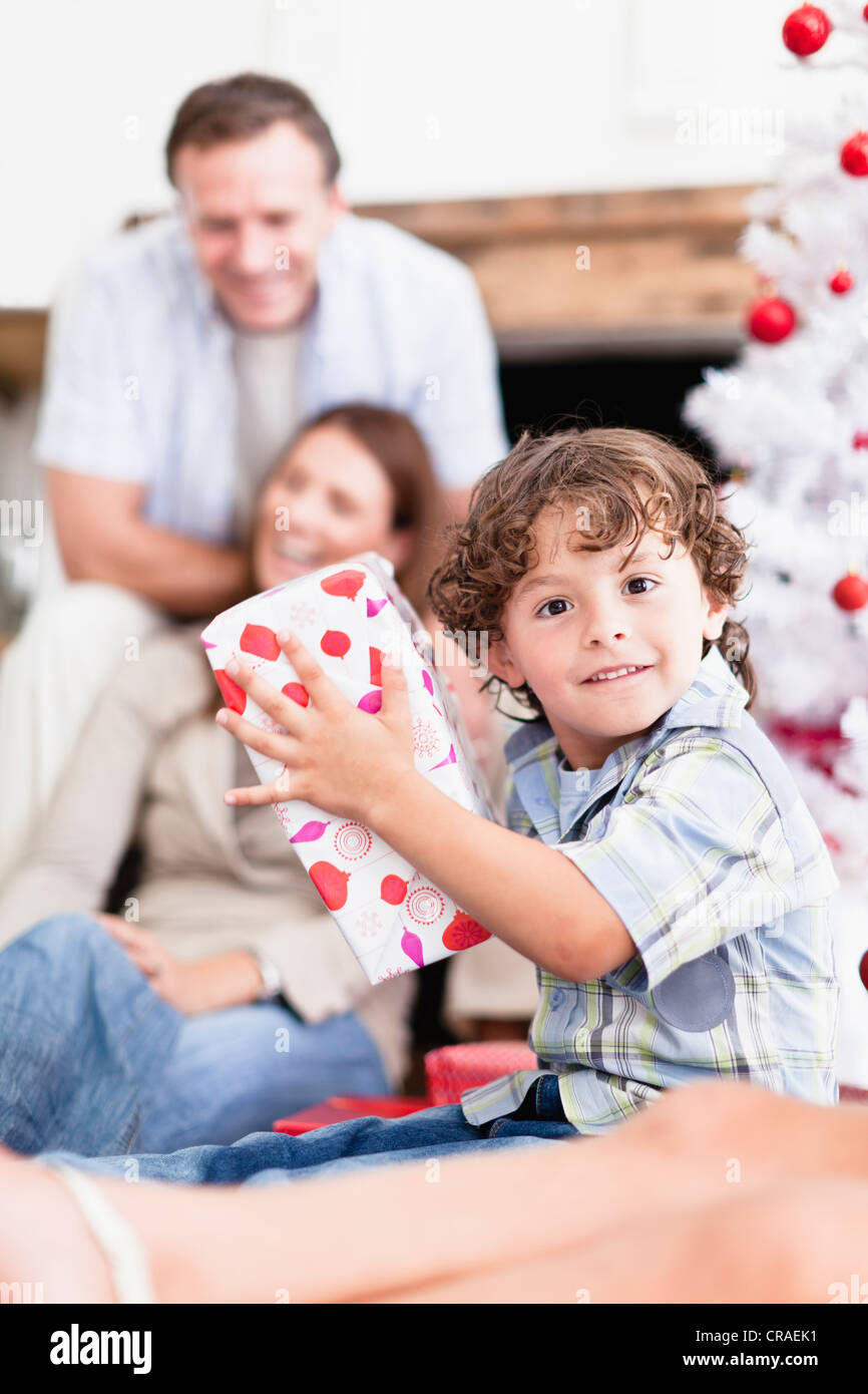 Boy shaking wrapped Christmas gift Stock Photo