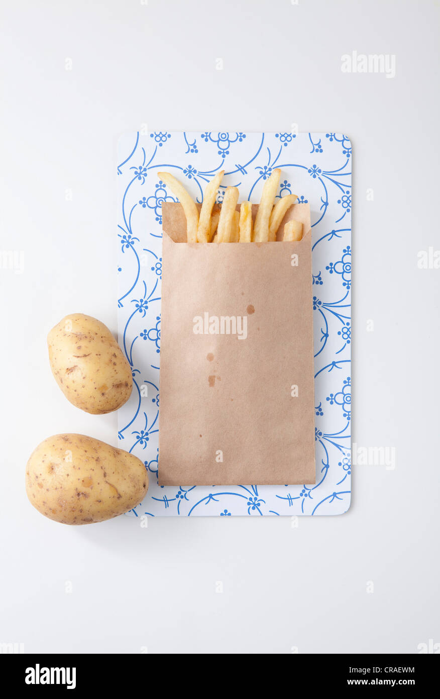 Shoestring French Fries In White Paper Bag On Picnic Table Stock
