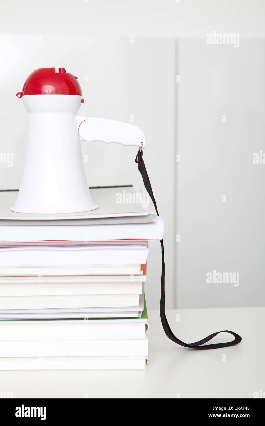 Megaphone on a stack of paper work, office, symbolic image for clear statements Stock Photo