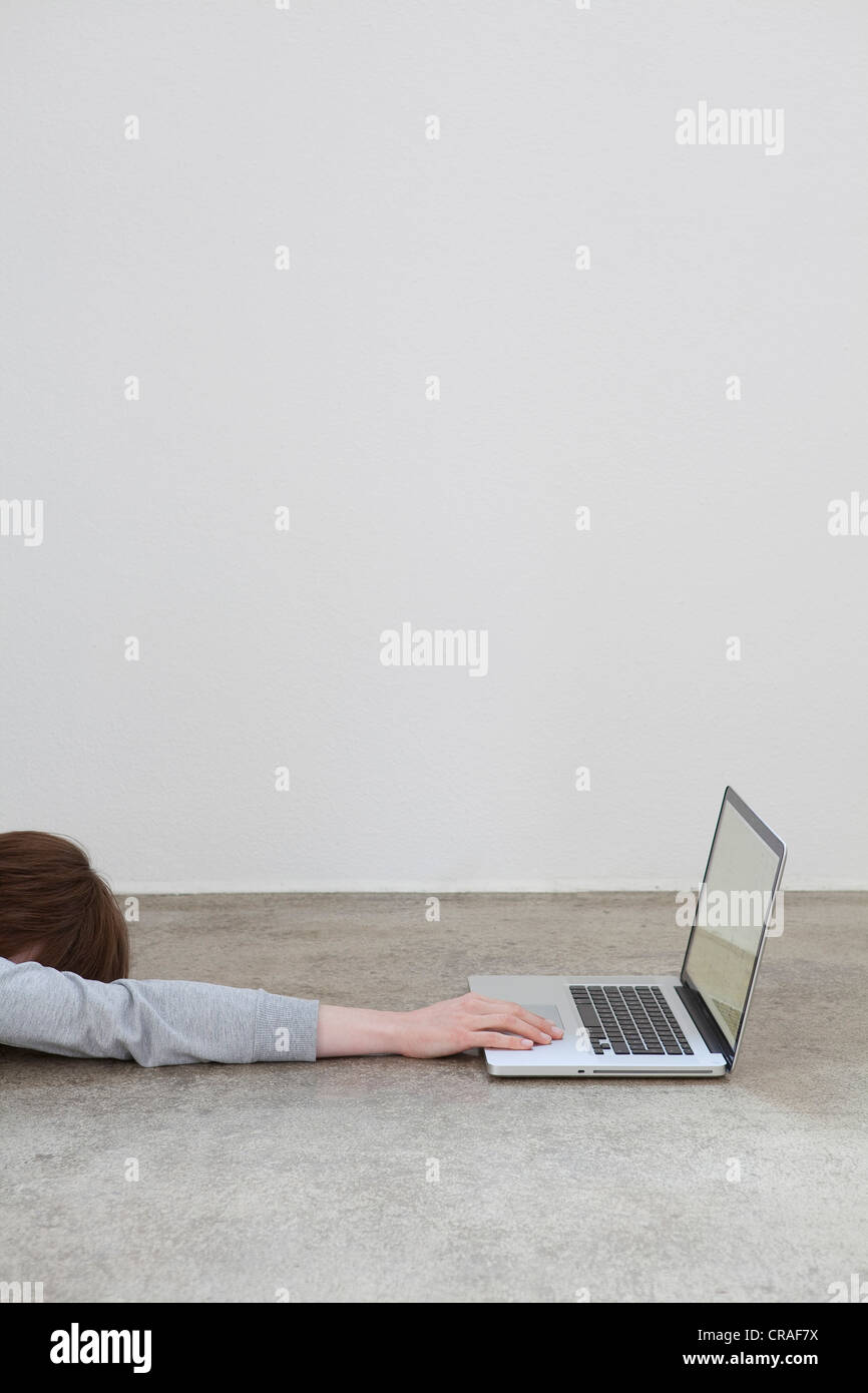 Woman has reached out for a laptop and fallen asleep Stock Photo