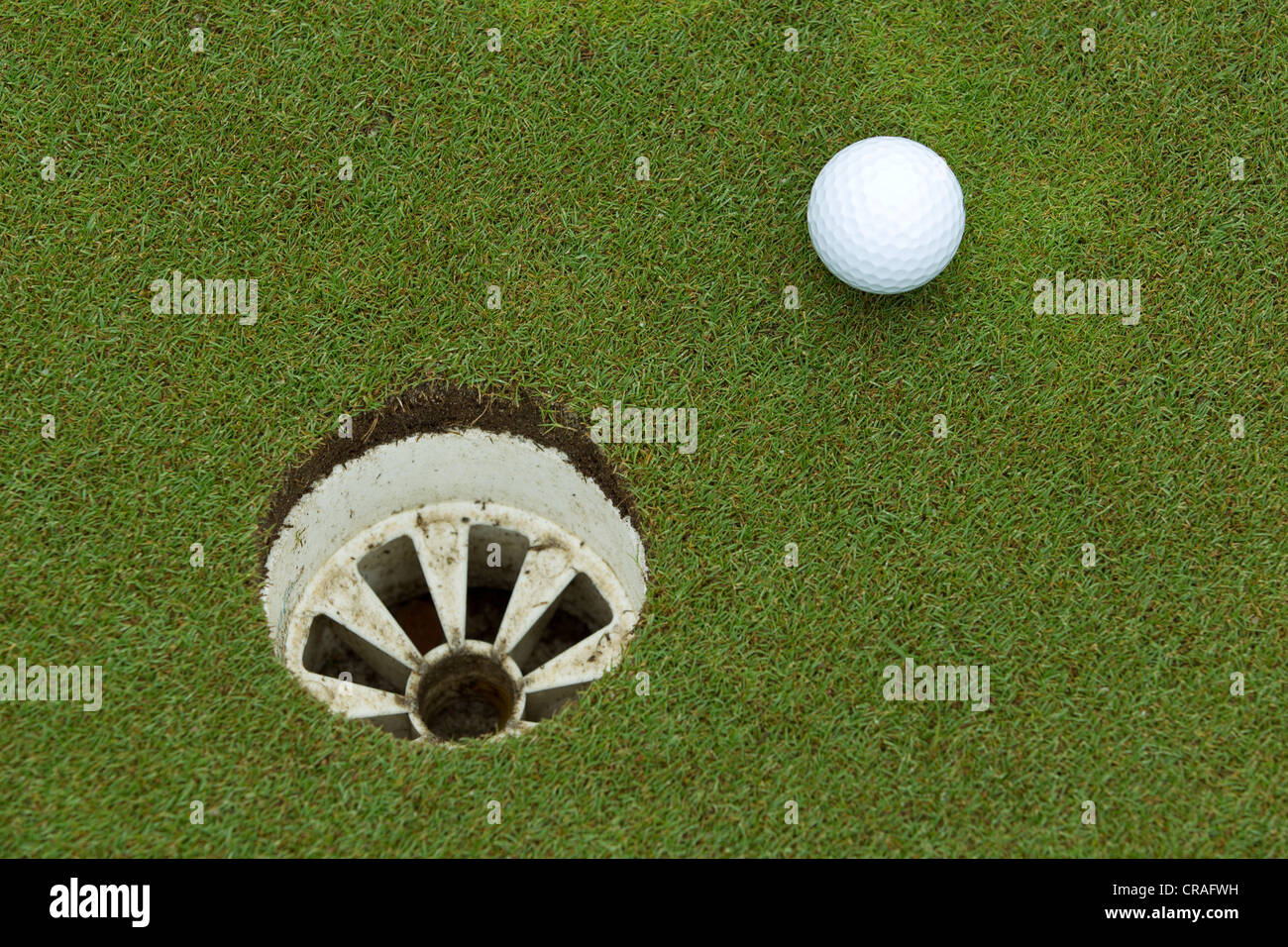 A golf ball and hole Stock Photo Alamy