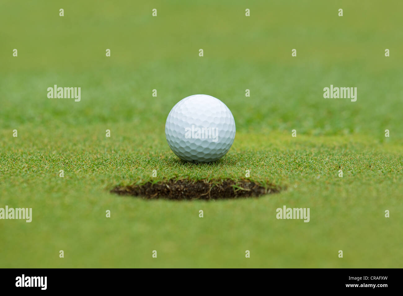 A golf ball and hole Stock Photo Alamy