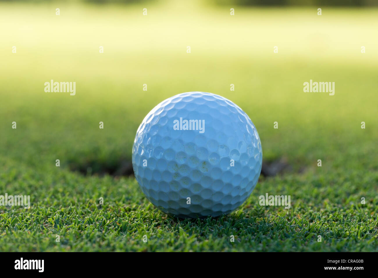 A golf ball and hole Stock Photo Alamy