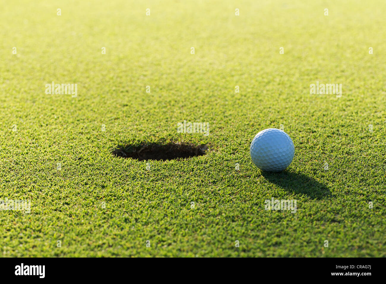 A golf ball and hole Stock Photo Alamy