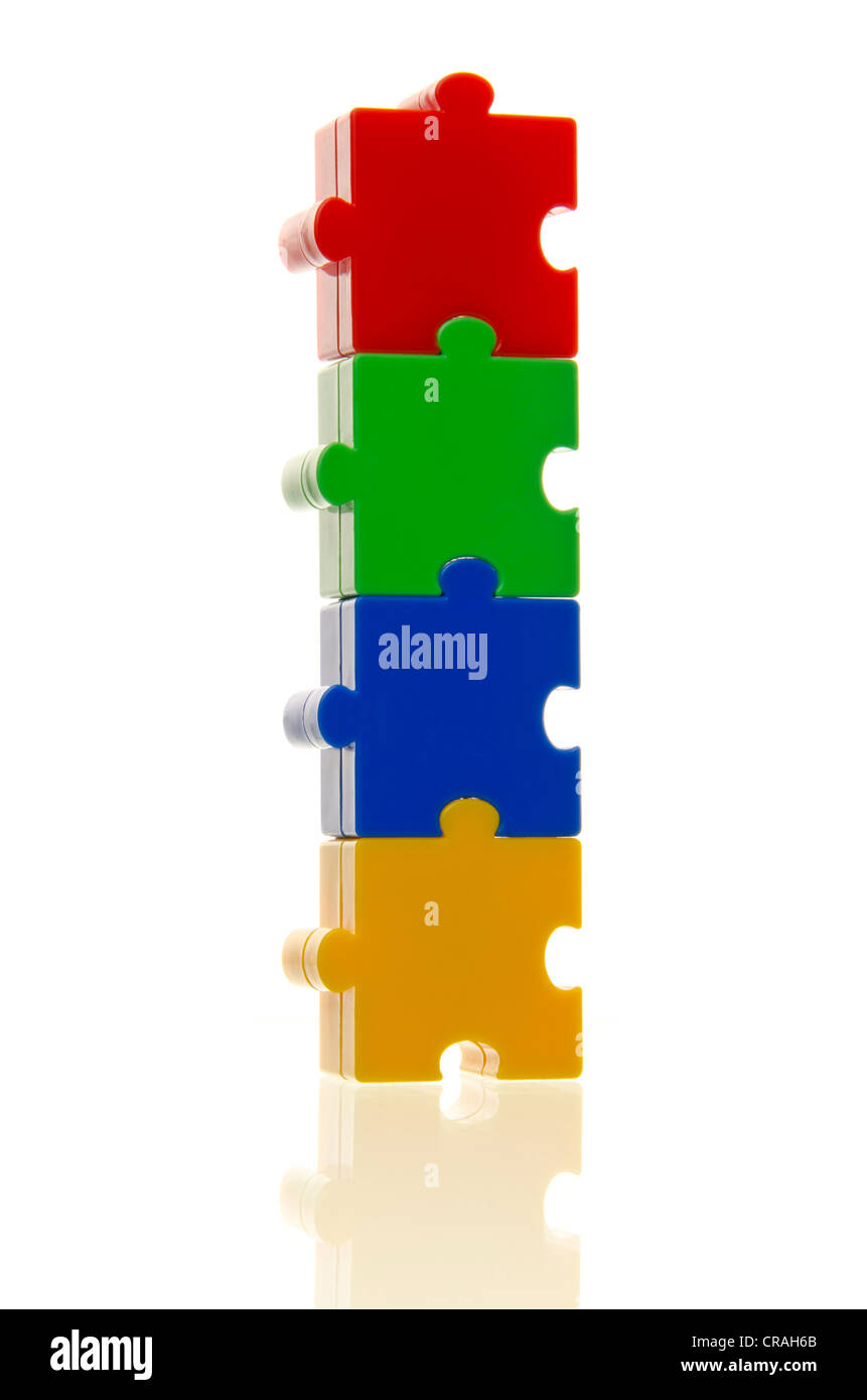 Four colourful puzzle pieces stuck on top of each other, connected, symbolic image for cohesion Stock Photo