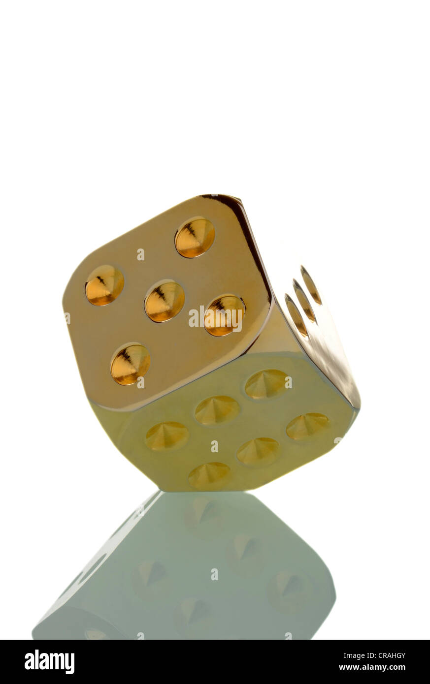Golden die standing on one of its edges Stock Photo