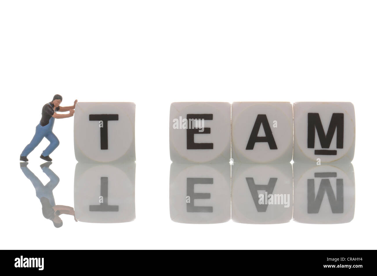 Small figurine of a workman pushing letters of the word 'team' together, symbolic image Stock Photo